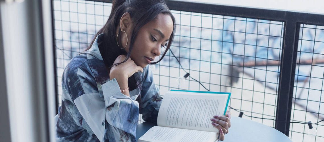 An inspiring woman reading and reflecting on her personal story for a memoir project.