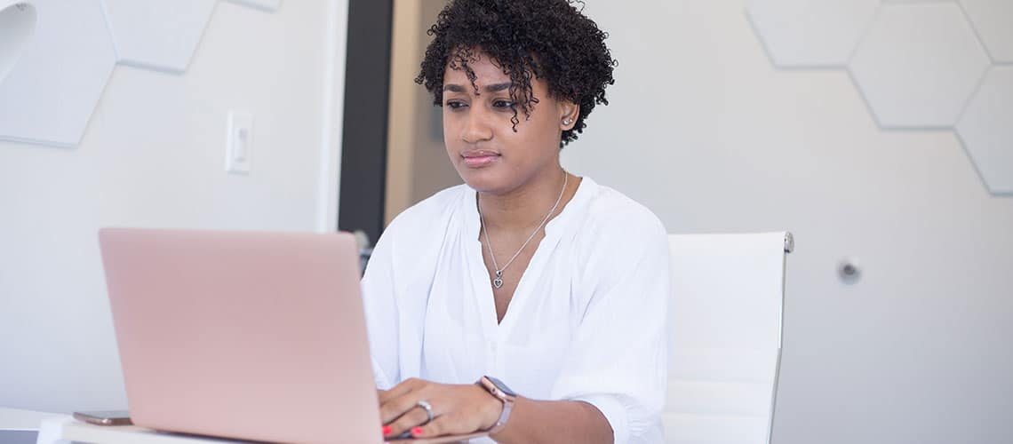 Woman working on laptop, exploring personal values for branding success.