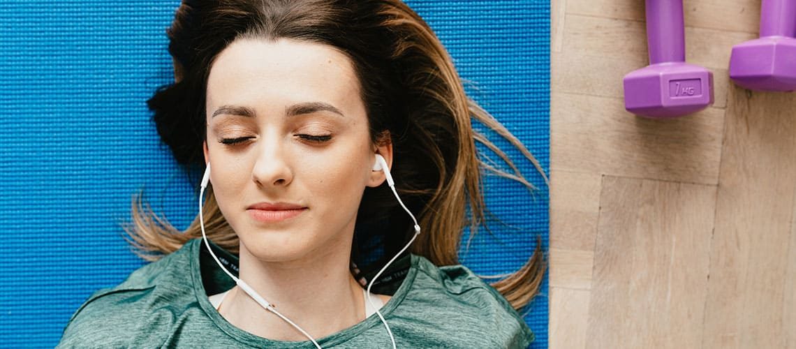 Woman relaxing with headphones, enjoying a creative break outdoors.